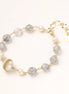 Gold-plated bracelet with white freshwater pearls and translucent grey crystals, featuring mesh-wrapped baroque pearl centerpiece