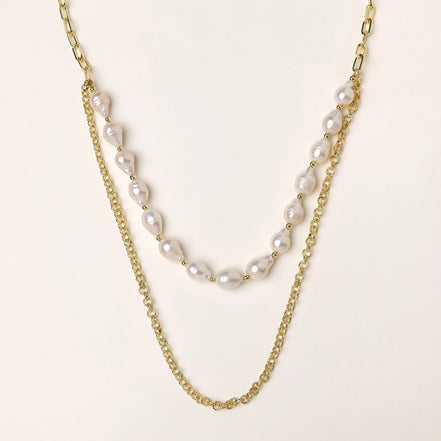 Layered gold chain necklace with irregular freshwater pearls on cream background, showing adjustable dual-strand design.