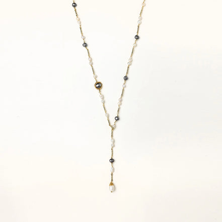 Long gold-plated necklace with alternating white and gray freshwater pearls spaced along delicate chain segments