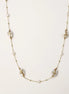 Delicate gold-plated necklace featuring translucent leaf-shaped baroque pearls and round freshwater pearls on neutral background.