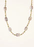Long gold-plated necklace with iridescent baroque pearls and round freshwater pearls on cream background