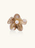 Elegant floral pin with peachy shell petals, gold radiating spokes, and white freshwater pearl center on cream background.