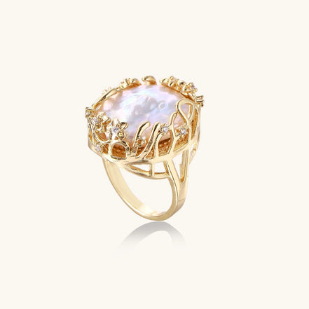 Ornate gold-plated ring with large baroque pearl in decorative vine-like setting with small crystal accents