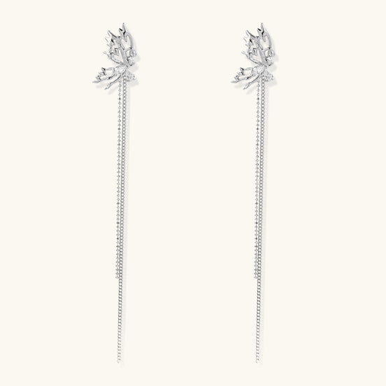 Long gold-plated earrings with star motifs and delicate chain tassels cascading down, featuring zirconia accents.