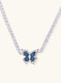 Gold-plated tennis chain necklace with blue denim butterfly pendant and zirconia stones on light background.