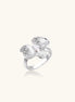 Gold-plated brass ring with textured orchid petals, zirconia stones, and center pearls on white background.