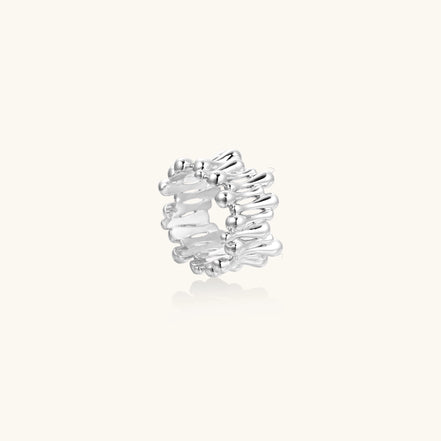 Close-up of an artistic gold-plated brass ring with multiple twisted bands creating a sculptural flowing design