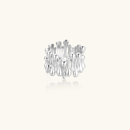 Close-up of an artistic gold-plated brass ring with multiple twisted bands creating a sculptural flowing design