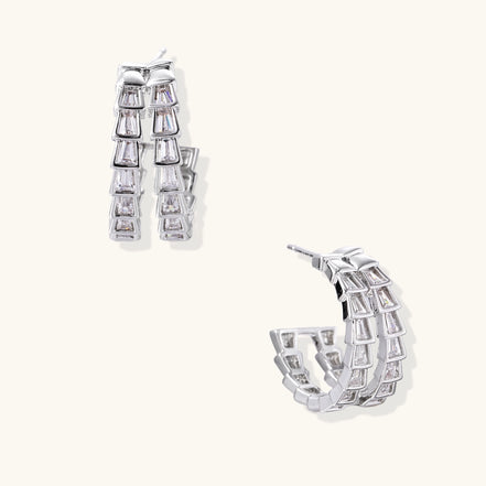 Gold-plated huggie hoops featuring vertical rows of clear baguette zirconia stones in geometric linear design