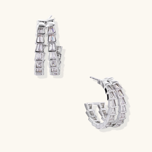 Gold-plated huggie hoops featuring vertical rows of clear baguette zirconia stones in geometric linear design
