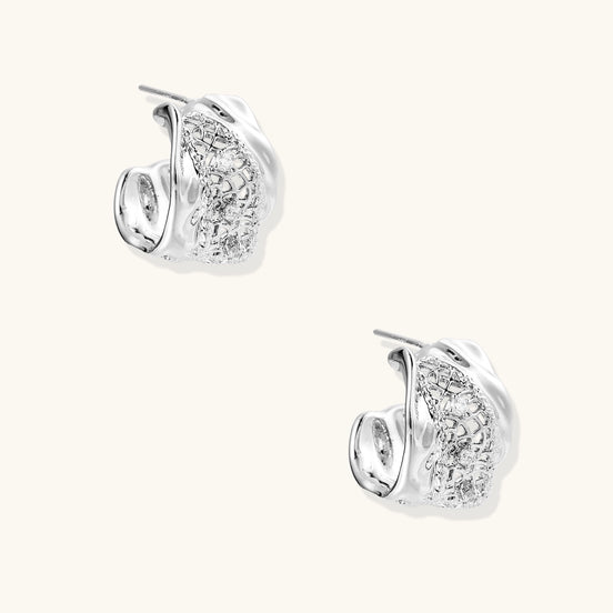 Small gold-plated brass hoop earrings with geometric lattice pattern and zirconia accents on white background.