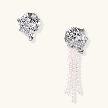 Intricate gold-plated geometric dangle earrings with zirconia stones and pearl drops on neutral background