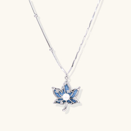 Gold-plated lotus pendant necklace with blue zirconia stones and white beads on adjustable layered chains