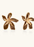 Large gold-plated flower earrings with brown enamel marbled petals on beige background, showing intricate floral design.
