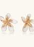 Large floral stud earrings with gold-plated brass petals and white enamel centers on neutral background