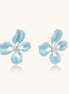 Turquoise blue enamel flower earrings with crystal centers and gold-plated brass posts on white background.