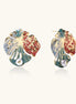 Colorful enamel monstera leaf earrings with pearl accents in teal, coral and gold tones on neutral background.