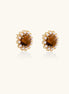 Gold-plated stud earrings with round tiger's eye stones surrounded by small pearls in a floral pattern.