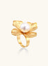 Gold-plated brass ring with dimensional 5-petal flower design and white cotton pearl center on neutral background.