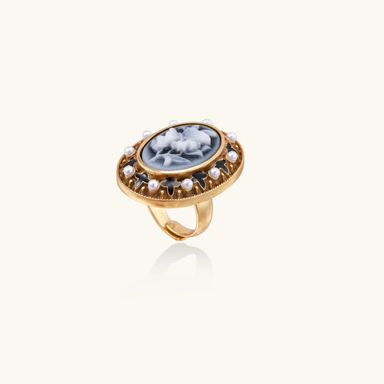 Oval cameo ring with blue-grey floral design surrounded by white shell pearls in gold-plated brass setting