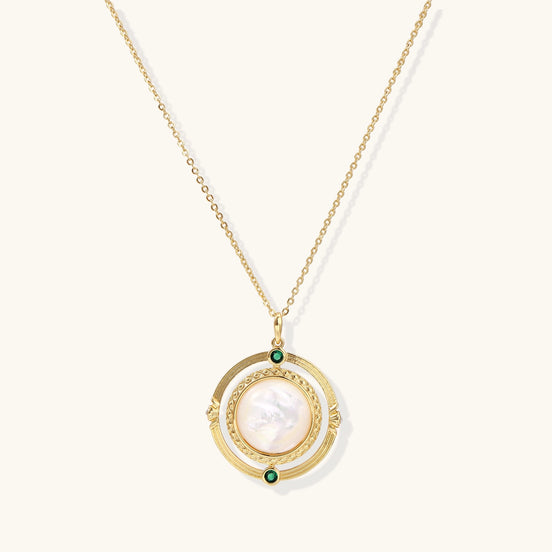 Gold-plated pendant necklace with circular orbital design, iridescent mother-of-pearl center and green zirconia accents