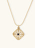Gold-plated square pendant with ornate scrollwork featuring central blue lapis lazuli stone on ball chain