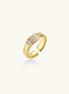Gold-plated brass cuff ring with textured band and rectangular cubic zirconia centerpiece on cream background