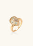 Gold-plated heart ring with turquoise enamel scrollwork and cubic zirconia stones on white background