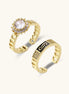 Two gold-plated brass rings with chain-link bands, one featuring a round cubic zirconia halo, one with black enamel accent.