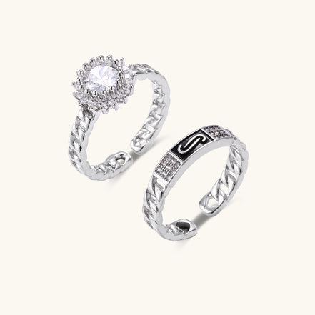 Two gold-plated rings with chain-link bands, one featuring cubic zirconia halo setting, displayed on neutral background