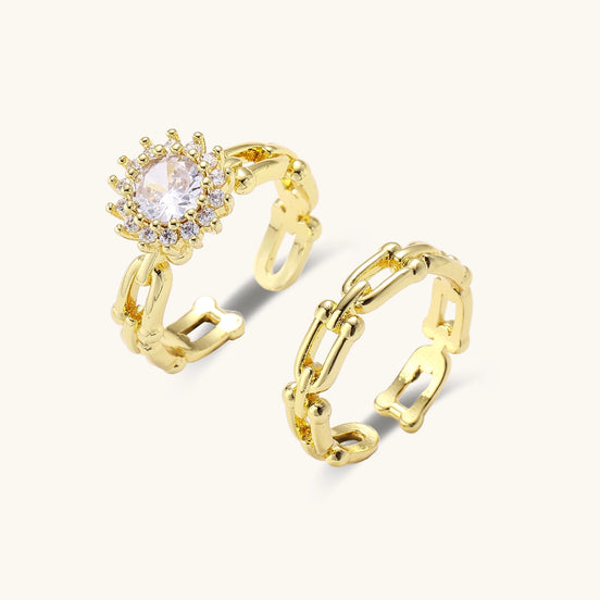 Two gold-plated rings with cubic zirconia halo design and chain-link band on white background, adjustable sizing.