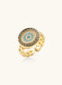 Gold-plated brass ring with Greek key border, evil eye center, and turquoise cubic zirconia stones in chunky chain band style.