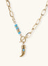 Gold-plated chain necklace with toggle clasp, turquoise beads, and curved horn pendant with inset turquoise stone on light background.