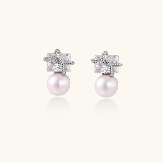 Gold-plated stud earrings with square crystal tops wrapped in twisted wire and freshwater pearl drops on white background