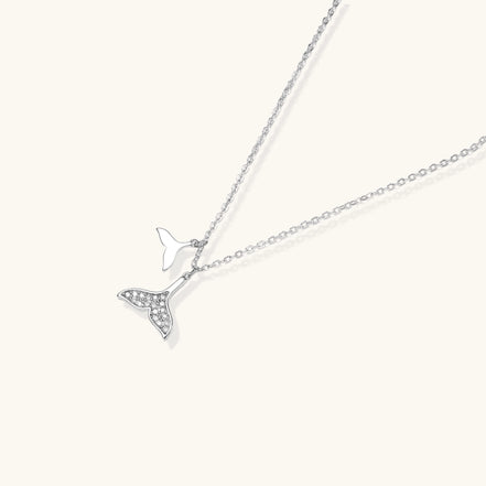 Delicate 14K gold-plated whale tail pendant necklace with sparkling crystal details on fine chain against white background.