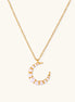 Delicate 18K gold plated necklace featuring crescent moon pendant with white shell pearl beads on neutral background.