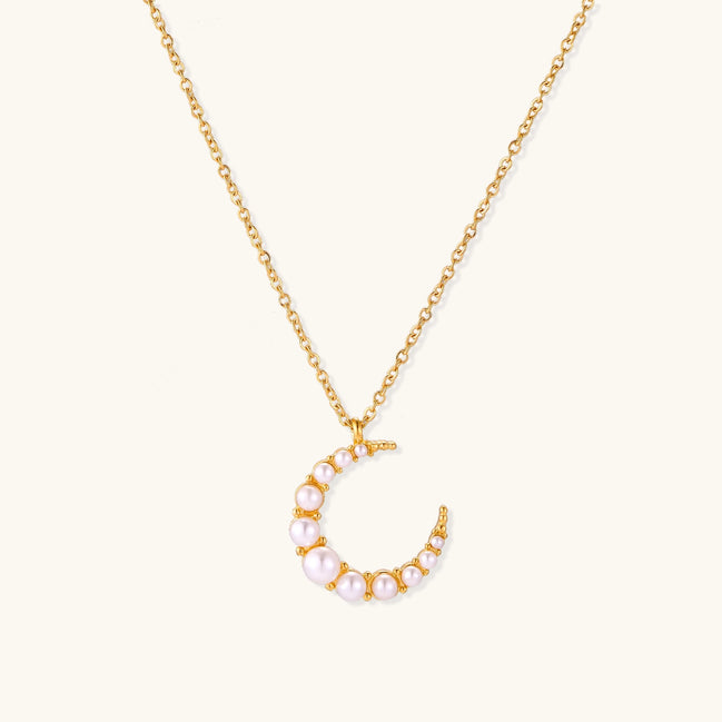 Delicate 18K gold plated necklace featuring crescent moon pendant with white shell pearl beads on neutral background.