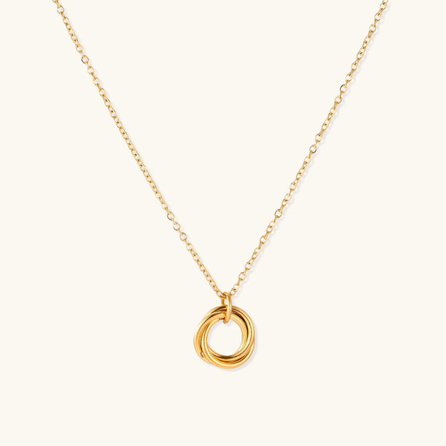 Close-up of a gold-plated stainless steel necklace with interlocking twisted ring pendant on white background