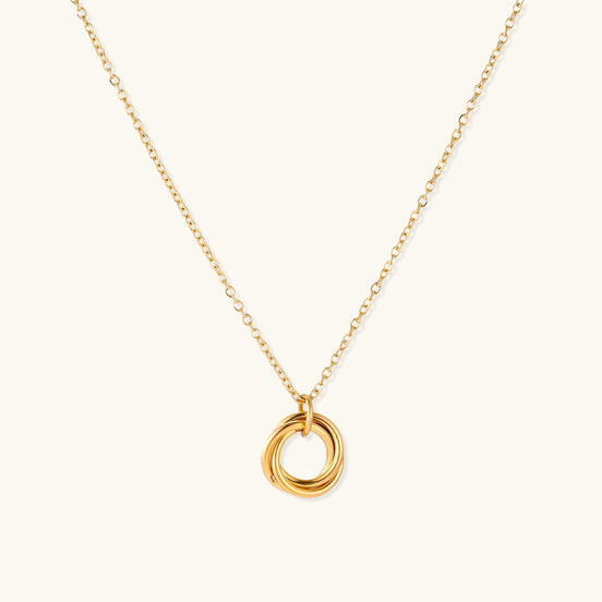Close-up of a gold-plated stainless steel necklace with interlocking twisted ring pendant on white background
