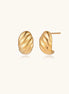 Pair of gold-plated twisted stud earrings with sculptural spiral design displaying elegant curved ridges on cream background.