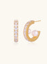Gold-plated hoop earrings with crystal pavé and floating freshwater pearls inside the circular design.