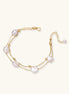 Double-strand gold bracelet with irregular baroque pearls and smooth freshwater pearls on cream background.