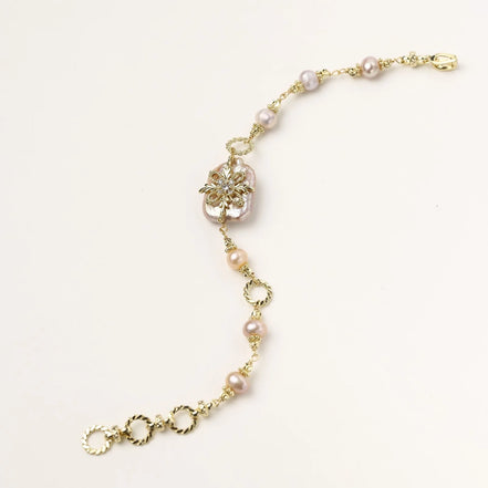 Gold-plated bracelet with pink baroque pearl centerpiece, floral connector, and freshwater pearls