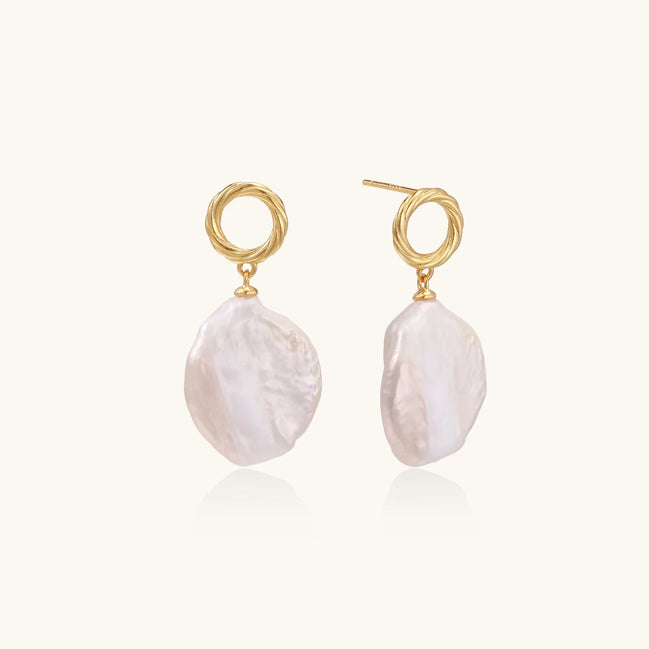 18K gold vermeil twisted circle studs with organic white baroque pearl drops on cream background