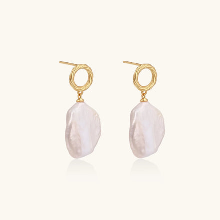 18K gold vermeil twisted circle studs with organic white baroque pearl drops on cream background