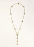 Gold-plated lariat necklace with baroque pearls and textured caps on cream background, showing adjustable Y-shaped design.