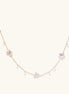 Gold vermeil chain with iridescent star-shaped baroque pearls and small round freshwater pearl drops on cream background.