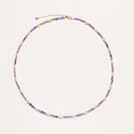 Delicate 18K gold vermeil necklace with alternating lavender zirconia beads and white freshwater pearls on cream background