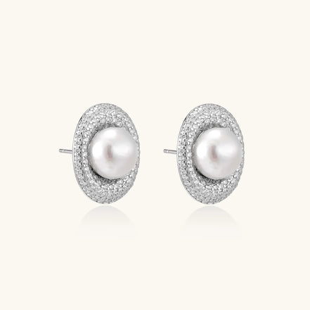 Oval rhodium-plated silver studs featuring freshwater pearls surrounded by pavé crystal halo on white background