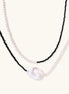 Double-strand necklace with black faceted quartz and white pearls featuring an oversized baroque pearl centerpiece